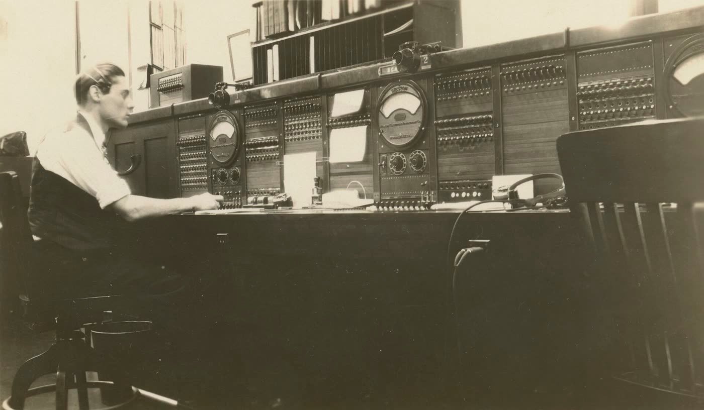 Opérateur devant un ancien standard téléphonique à cadrans